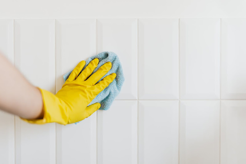 A woman doing bathroom cleaning from a cleaning service company.